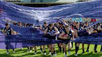Launceston co-captain and now president Scott Stephens leads his team through the banner for the 2008 NTFL grand final against Burnie played at Latrobe Oval. It was the last match played in the competition. Picture file