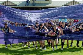 Launceston co-captain and now president Scott Stephens leads his team through the banner for the 2008 NTFL grand final against Burnie played at Latrobe Oval. It was the last match played in the competition. Picture file
