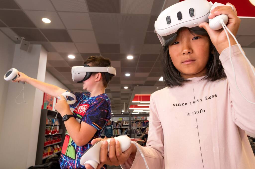 Jing Jing Fan and Jakobie Bell try out VR headsets at the Launceston Library. Picture by Philip Biggs