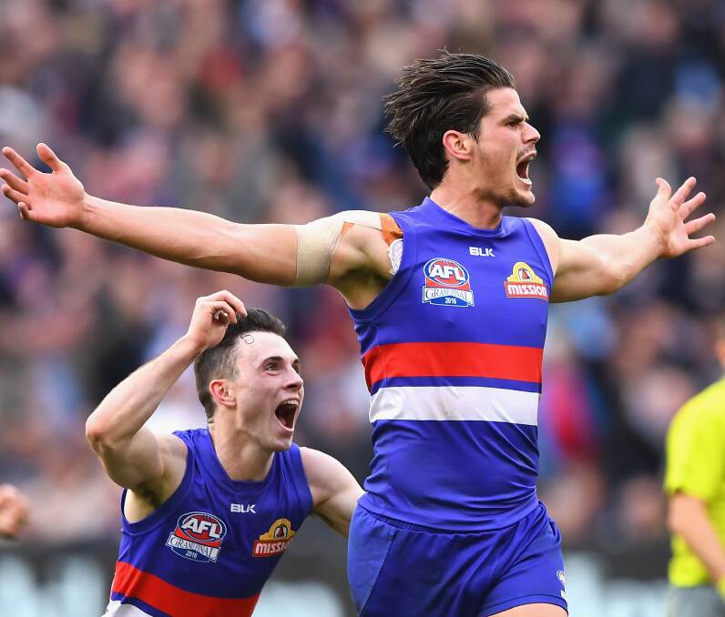 ALL FOR THE FANS: Tom Boyd, of the Bulldogs, celebrates kicking a goal during the 2016 AFL grand final match where a record crowd turned out to see history being made.