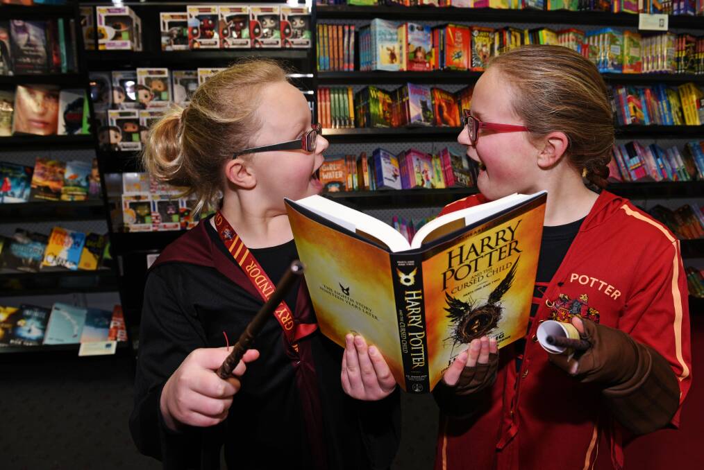 MAGIC: Elyse and Grace Campbell couldn't wait to read the newly released Harry Potter and the Cursed Child book during the launch at Birchalls book shop in Launceston. PICTURE: Scott Gelston.