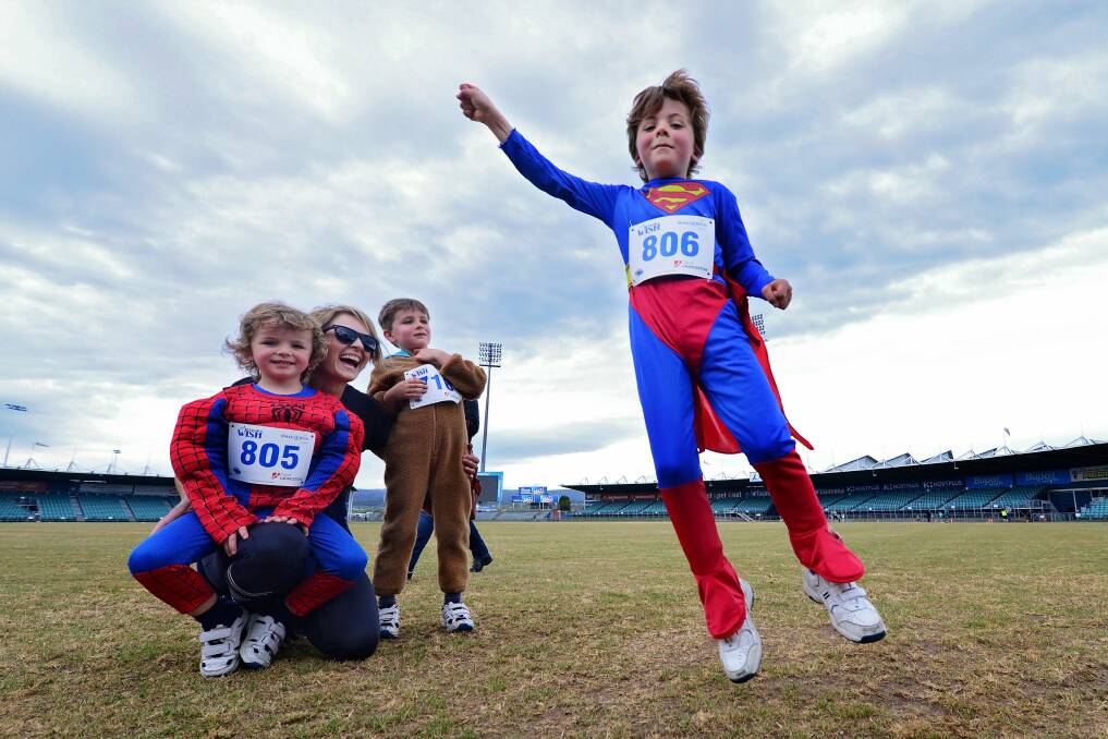Superman Jackson Webster getting ready to fly past his mum Catherine, brother Levi and friend Flynn Maartensz at the Run For A Wish event. Pictures: Phillip Biggs.