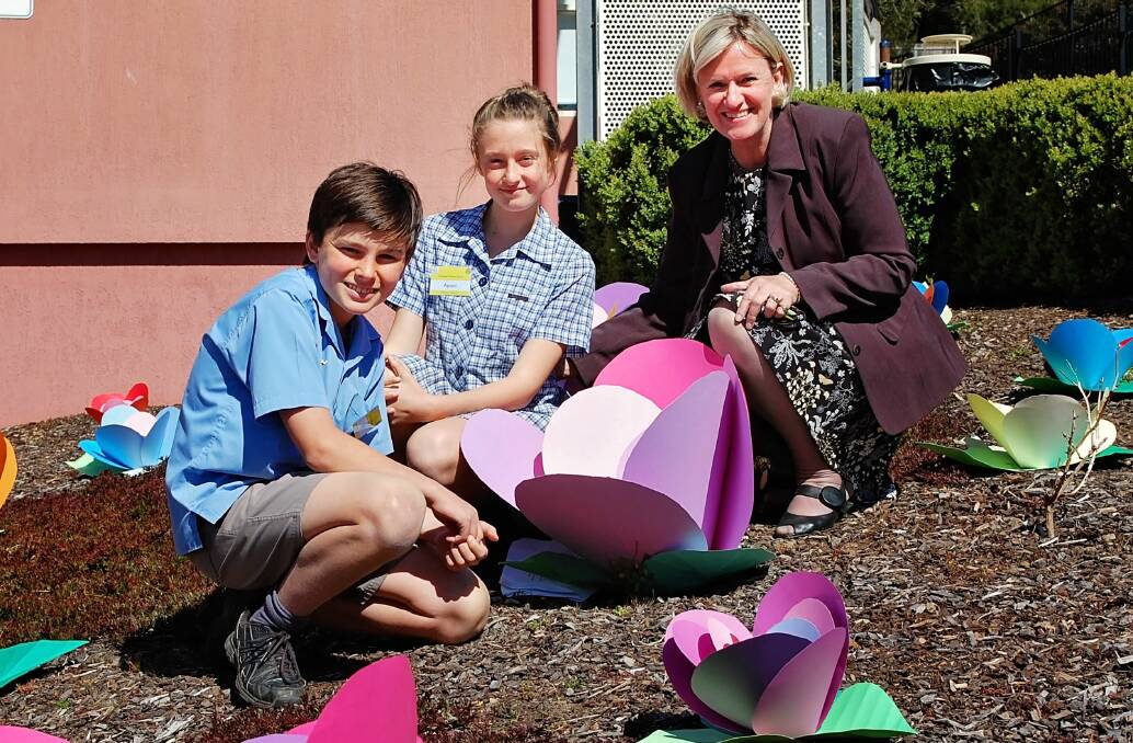 CELEBRATING: Trevallyn Primary School pupils Will Hugo and Aponi Hulse, both 12, with principal Annette Hollingsworth celebrating the school's centenary with specially made flowers. Picture: Michelle Wisbey