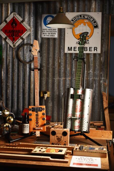 QUIRKY COOL: Bruce Trappes' Devil Guitars Tasmania cigar box guitars on display in Mr Trappes' shed and work space.
