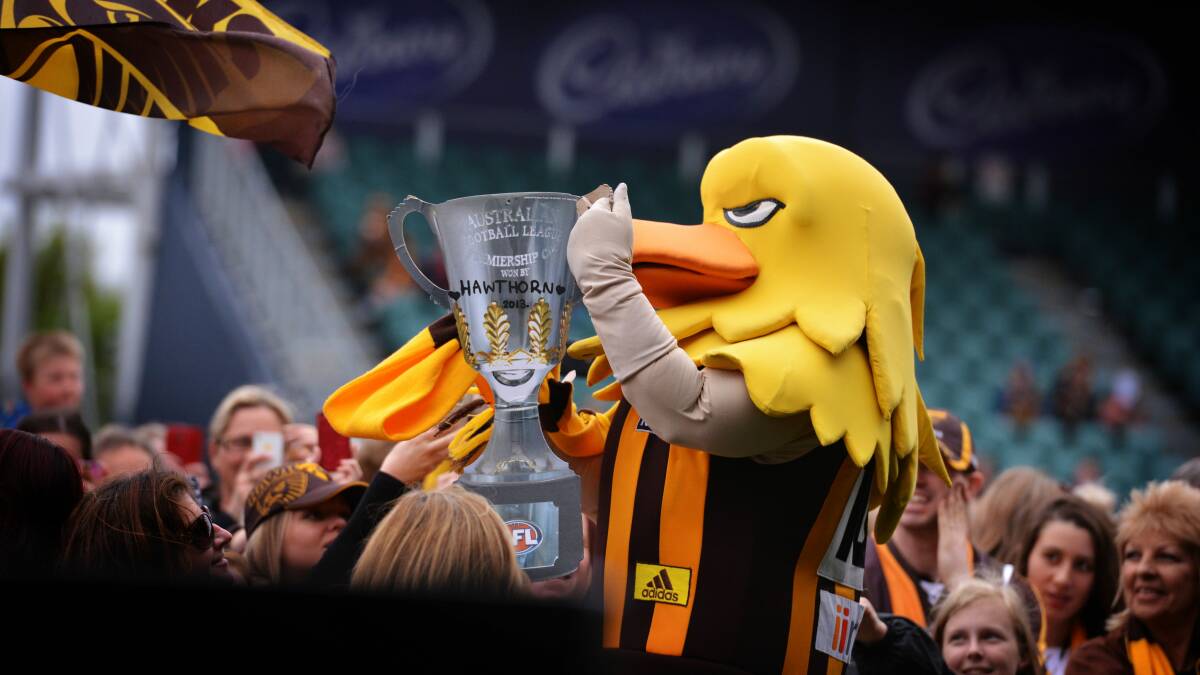 MASCOT: Hawka celebrates the 2013 premiership win with a cardboard cup in Launceston. Picture: Scott Gelston