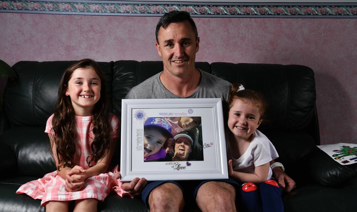 HONOURING TAMIEKA: Shaun Smith and his daughters Lily, 8, and Harper, 4, hold a photo of their beloved wife and mum Tamieka. Picture: Scott Gelston 