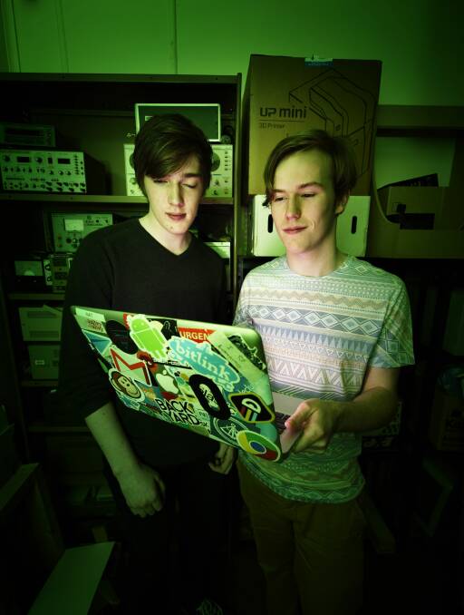 DISCOVERY: Nathaniel Bott, 19, and Grifin Brooks, 17, of Launceston, examine the prototype for a garbage collection app. Picture: Scott Gelston 