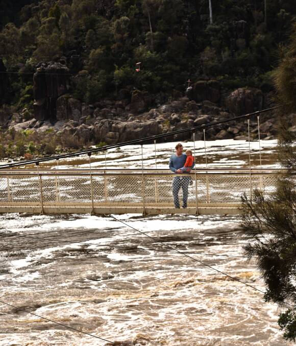 POURING: Scamander's Matt and Billy Blachford, 4, check out the floodwaters from the Alexandra Suspension Bridge in the Cataract Gorge. Picture: Scott Gelston 
