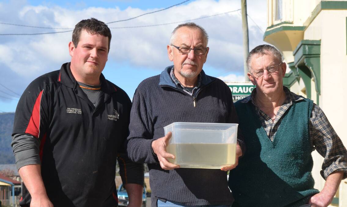 DISAPPOINTED: Ringarooma's Josh Webb, David Shaw and Kerry Singline with the town's water - straight from the tap. Picture: Toli Papadopoulos