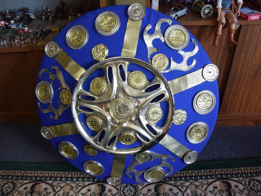 A Roman-style shield made with cut bits of tin and a hub cap among other materials.