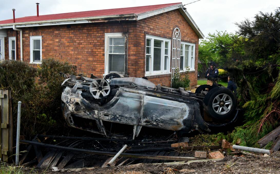 WANTED: Police are searching for a man who crashed an SUV into a Newnham front yard on Wednesday morning. The car burst into flames after flipping onto its roof. Picture: Neil Richardson
