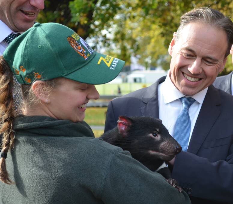 ALL SMILES: Zookeeper Elyshia Wignell and Environment Minister Greg Hunt with a Tasmanian devil in Hobart. Picture: Georgie Burgess