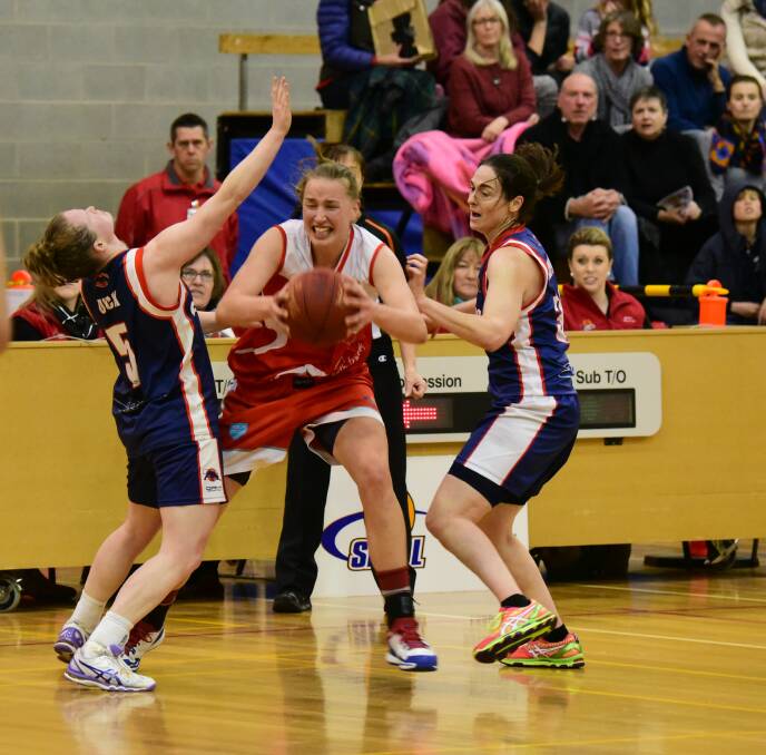 DETERMINED: Tornadoes' Mikaela Ruef fights to pass the ball against Geelong's Alex Duck and Natalie Hughes.
