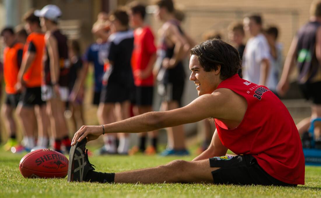 Possible debutant Dylan Headland does some stretching before the start of training.