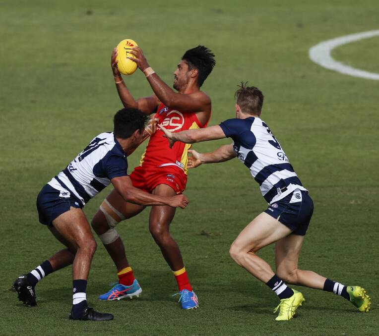  CATS CAN'T CATCH ME: Aaron Hall attempts to get the ball away under the pressure of two Geelong opponents. Picture: AAP Image/Dave Acree