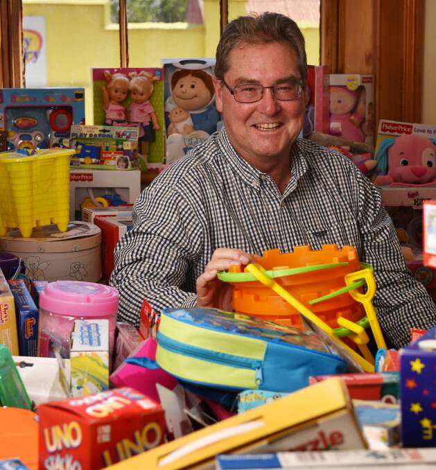Christmas relief: City Mission's communication relations manager, Brian Roach, surrounded by kids' Christmas gifts to go to those most in need in our community. 