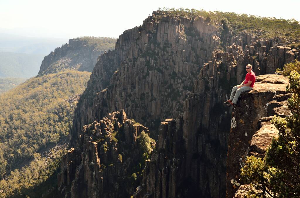 Dramatic views: Standing atop the dramatic cliffs of Devils Gullett, looking over Tasmania’s remote alpine Central Plateau. Picture: Tourism Tasmania & Dan Fellow 