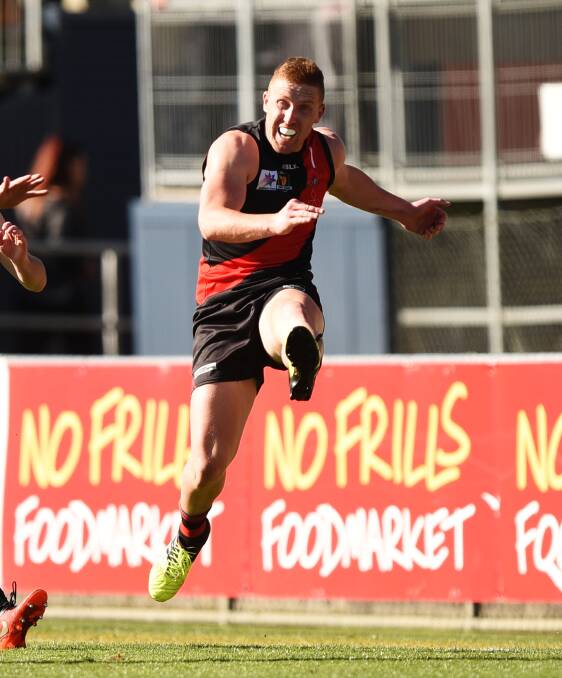 ONWARDS: North's Brad Cox-Goodyer boots the Bombers forward along the wing during the second quarter.