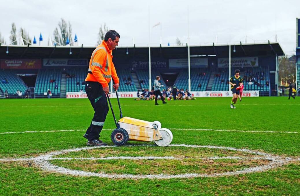 A final lick of paint is applied to Aurora Stadium's centre square before the Tasmanian State League final. Picture: Scott Gelston