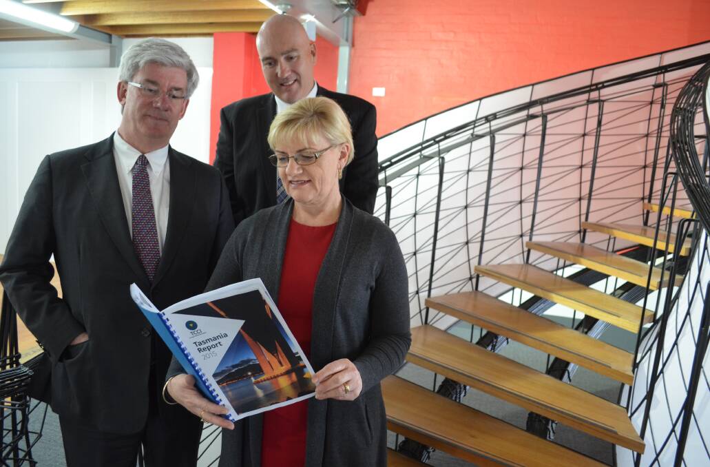Tasmanian economist Saul Eslake, Tasmanian Chamber of Commerce and Industry chief executive Michael Bailey, and B&E retail manager Kate Wagner look over last year's Tasmania Report.