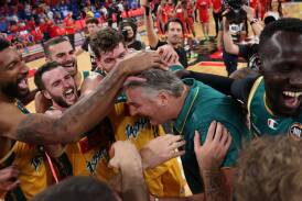 Tasmania JackJumpers players swarm coach Scott Roth after defeating Perth Wildcats. Picture by Getty Images