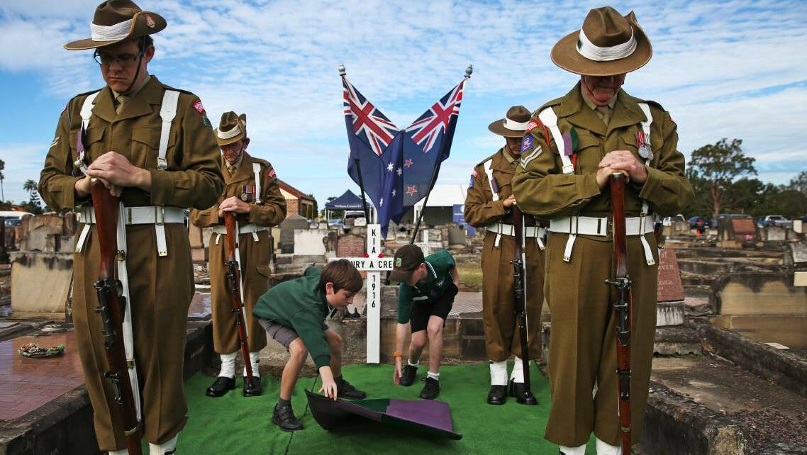 NEVER FORGOTTEN: Descendents of World War One Private Edward Cressy - Dean Coe and Ben Harragon - unveil a cross to commemorate his brother Private Harry Cressy at Sandgate Cemetery on Tuesday. Picture: Marina Neil