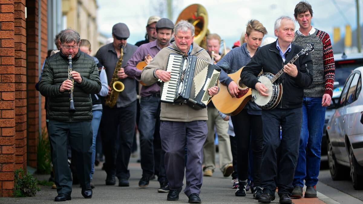 STREETS ALIVE: Bruce Gourlay with the piano accordion leads a procession along Marlborough Street in Longford for the Norfolk Plains Jazz Festival. Picture: Phillip Biggs
