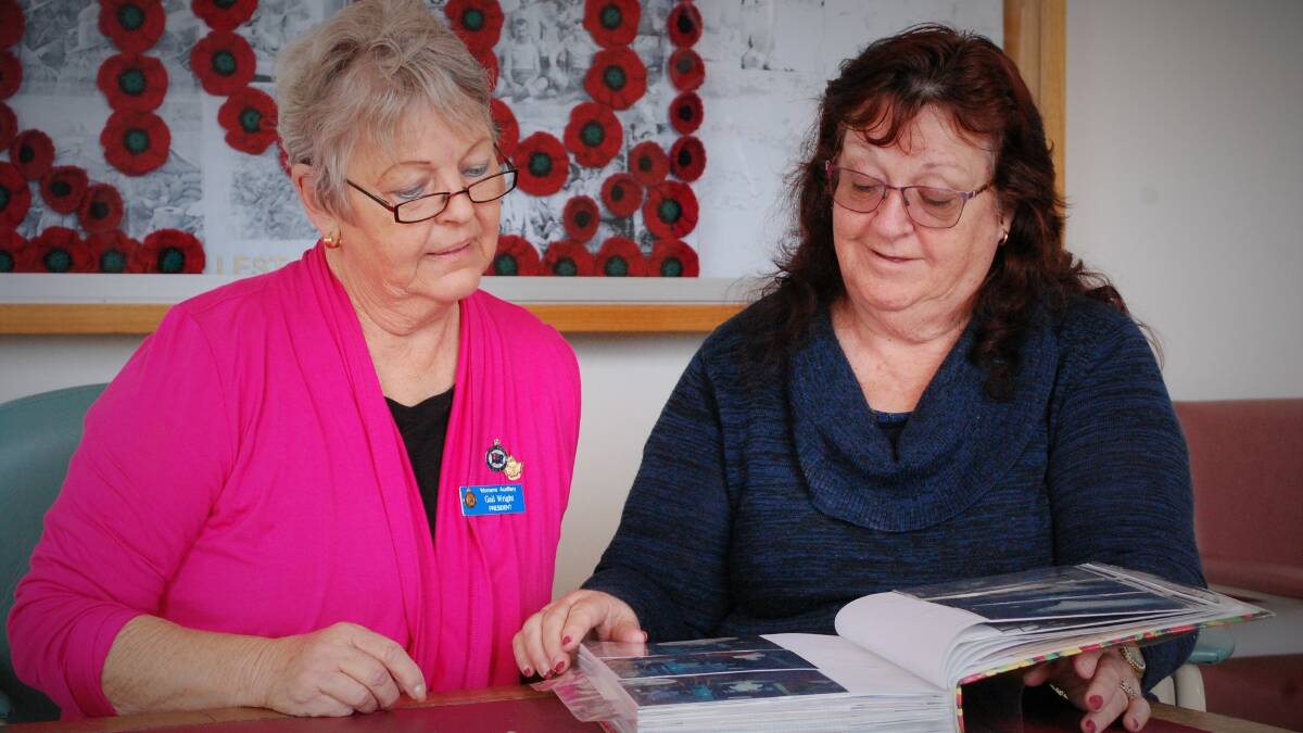 DEDICATED: RSLA Women's Auxiliary's Gail Wright and Ann Cash looking through the old photo album of 80 years of the group. Picture: Piia Wirsu