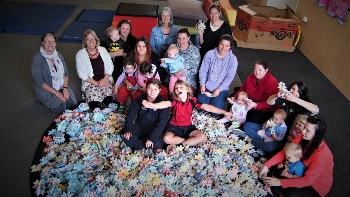 REACHING FOR STARS: Some of the volunteer community at the Burnie Child and Family Centre who have put their hands to work making 10,000 woven paper stars .