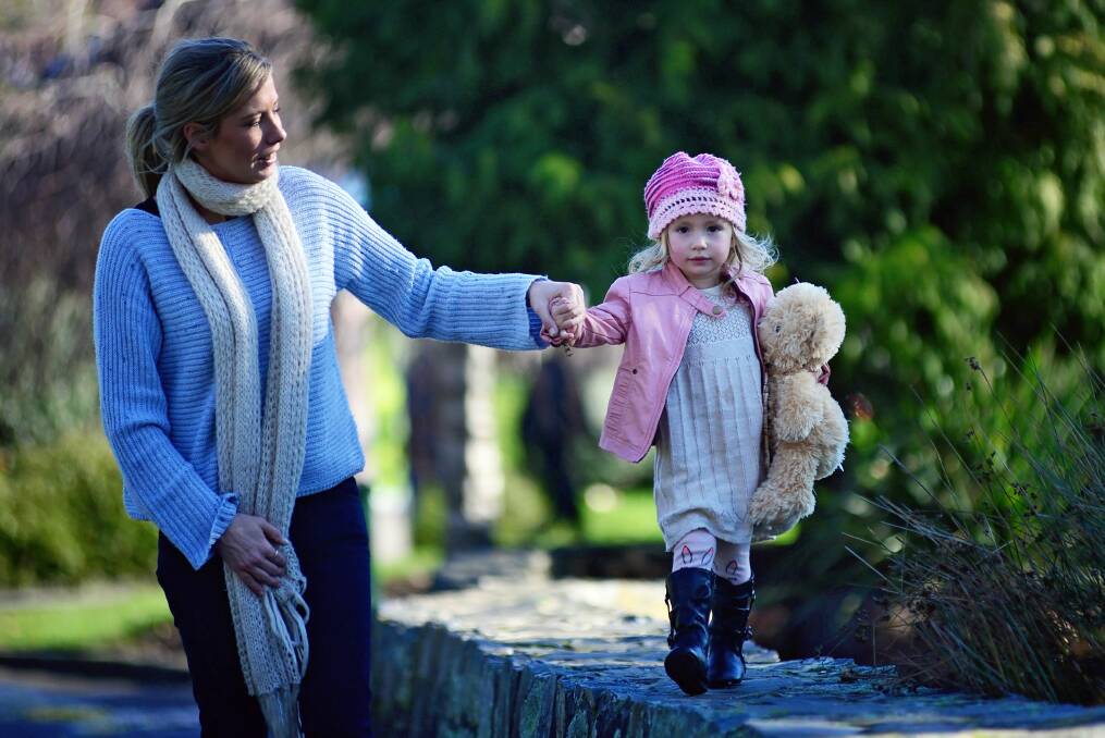 RUGGED UP: Toting beanies and scarves for the cold snap, Katie Nicholas of Trevallyn with her two year old daughter Stella, enjoying a moment of sun in City Park, Launceston. Picture: Phillip Biggs