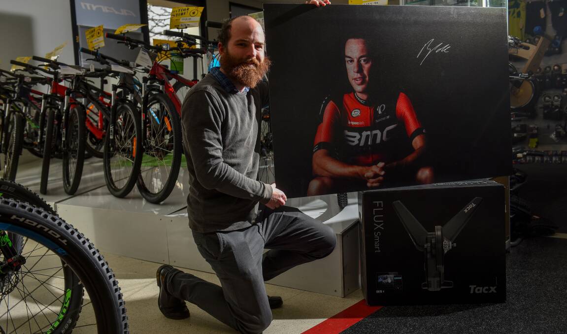 DONATED: Photographer Scott Gelston with the signed print of Richie Porte.