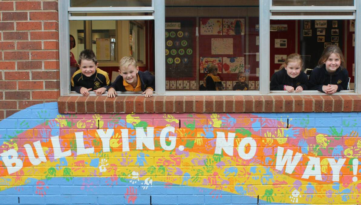 SAFE SCHOOL: Pupils Felix Page, 7, Harri Poke, 8, Bridie Frost, 8, and Nicole Parker, 7, with an anti-bullying mural at Deloraine Primary School.