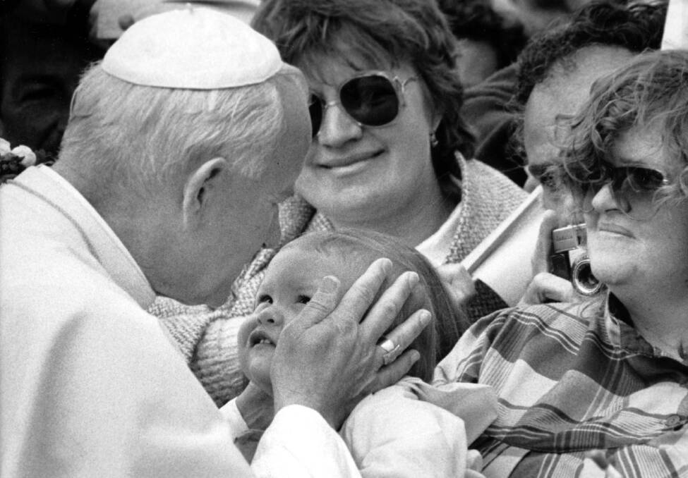 LOVING WELCOME: Pope John Paul II kisses a baby on arrival at Hobart Airport on November 27, 1986. He held mass at Elwick Racecourse and was seen by about 35,000 people during his seven-hour trip. Picture: Neale Duckworth.