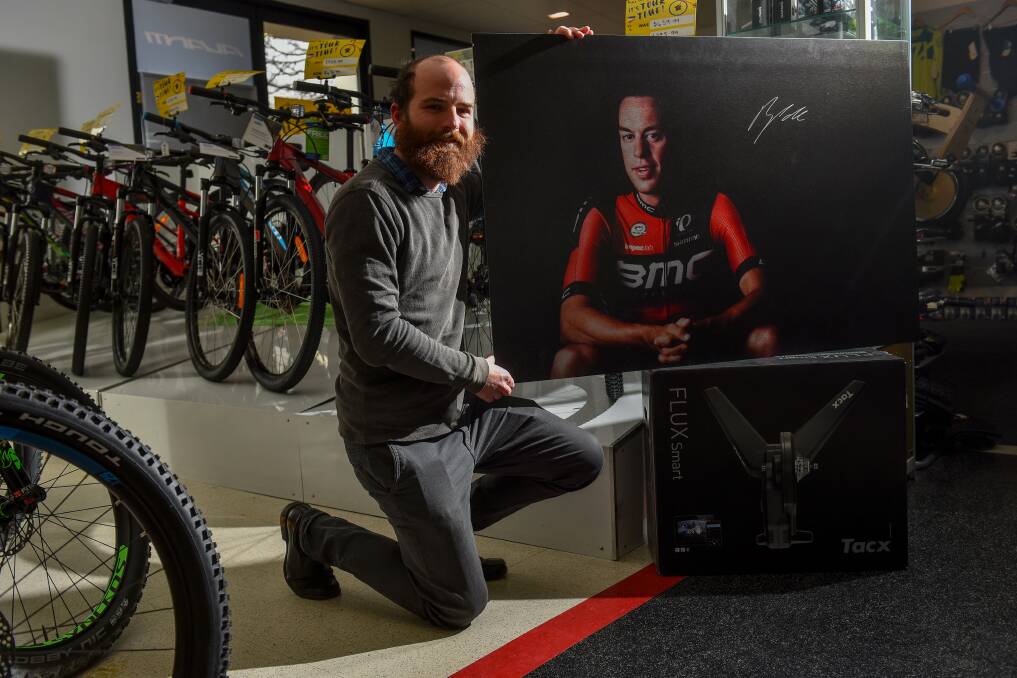 AUCTION: The Examiner's photographer Scott Gelston with the limited edition print of cyclist Richie Porte, which has also been signed by Porte. All funds raised by its sale will go to charity through the Winter Relief Appeal.