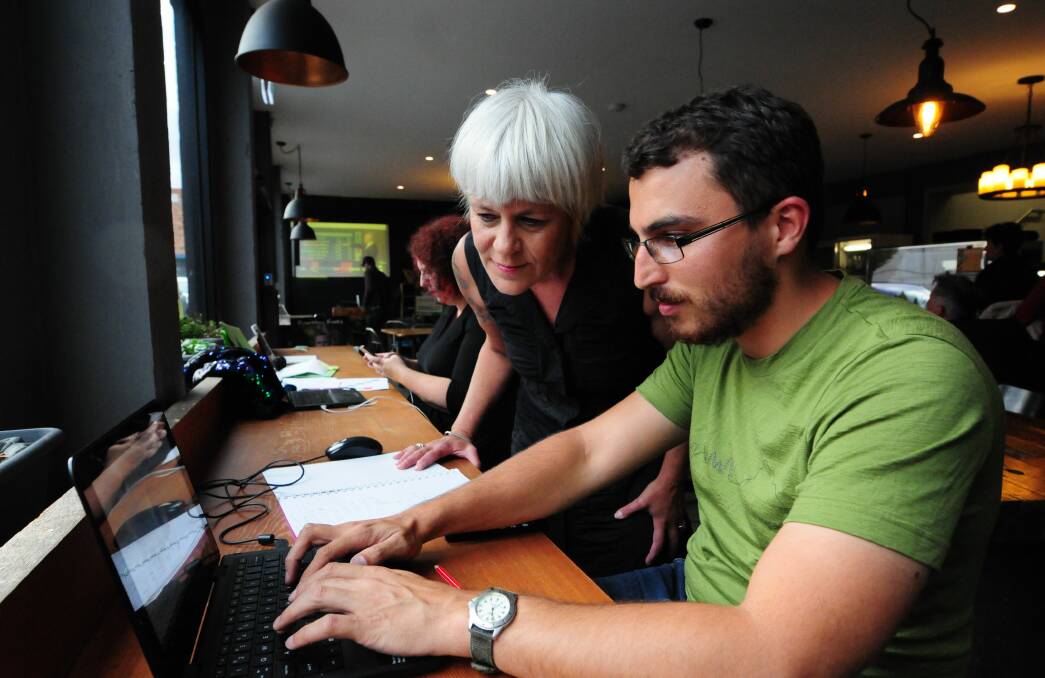 Bass Greens MHA Andrea Dawkins checks results with Thomas Robertson at the election after party at Earthy Eats in the Kingsway Launceston. Picture: Paul Scambler.