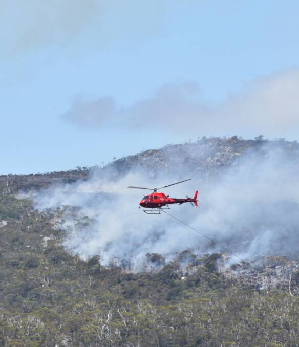 The TFS helicopter in action in January water bombing a section of the large bushfire at Cradle Mountain. Picture: Brodie Weeding.