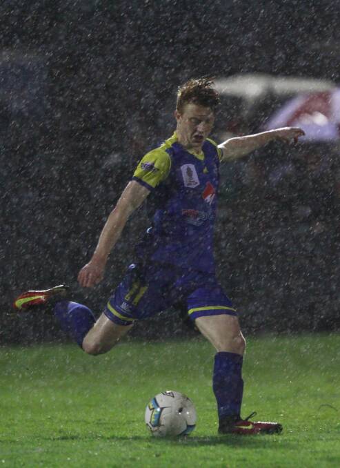 Devonport's Adam Gorrie takes his kick through the driving rain.