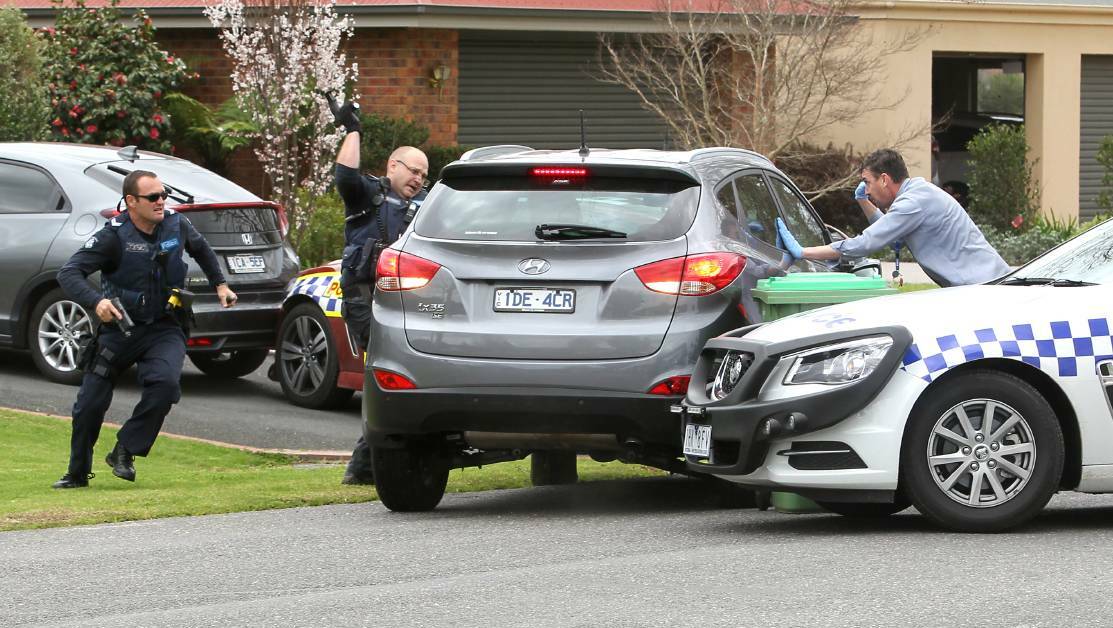 Police desperately try to smash the windows of the stolen car after their vehicles were rammed in Wodonga on Sunday. Pictures: BLAIR THOMSON