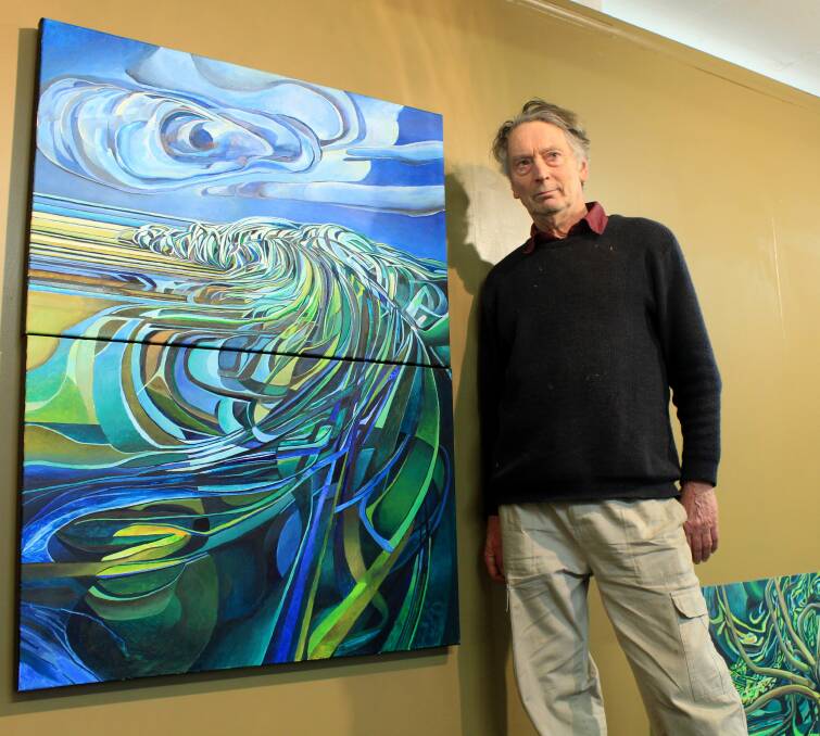 FLURRY OF COLOURS: Launceston artist Richard Crabtree hangs a piece inspired by Tasmania's East Coast ahead of his July exhibition. Picture: Hamish Geale