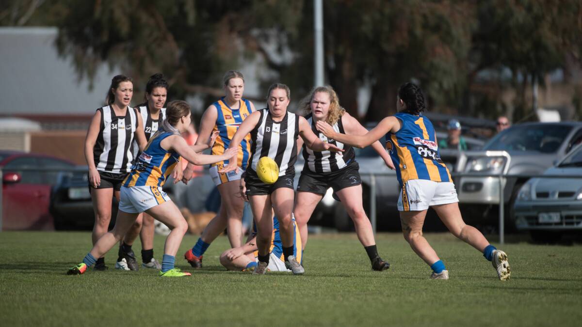EAGLE WINGS: Scottsdale's Gemma Blackberry manages to get a kick away before Evandale's Ebony Vocke and Kristy Penny can lay a tackle. Picture: Paul Scambler