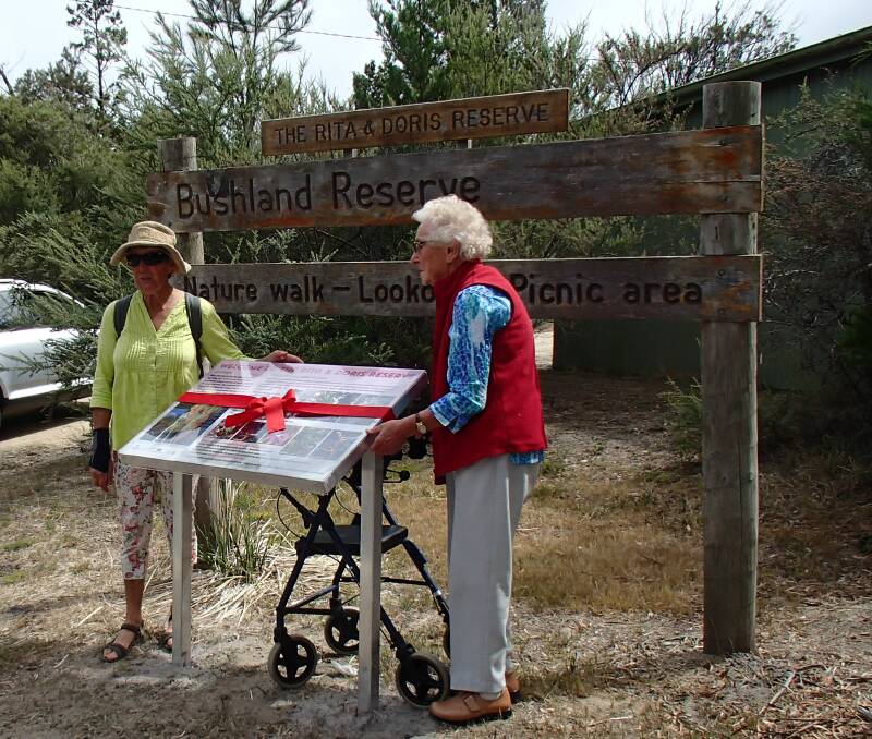 LEGACY: Freycinet resident Andrea Cole and 98-year-old Coles bay icon Rita Blazely cut the ribbon on a new interpretation sign at the Rita and Doris Reserve. Picture: Supplied 
