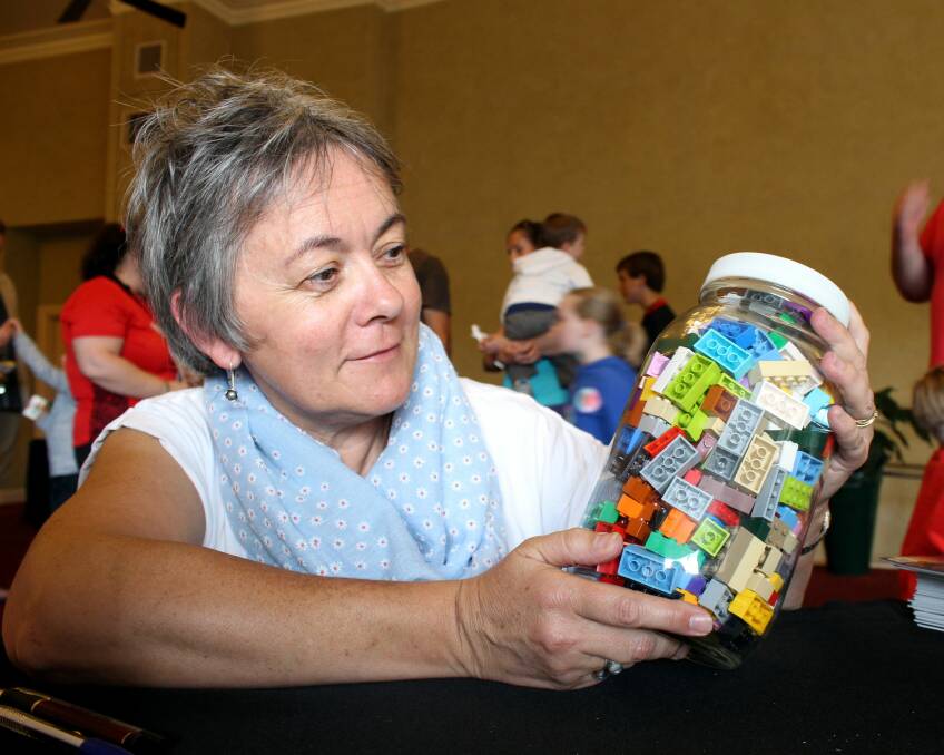 GUESSING GAME: Tasmanian Brick Enthusiasts publicity officer Giselle Cini tries her hand at estimating the number of lego bricks in a jar. Picture: Hamish Geale