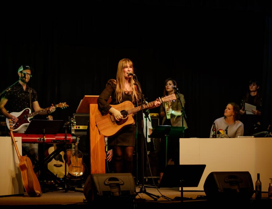 BICHENO TRIO: Pete Cornelius, Jane Germain and Eliza Spykers perform at Bicheno Town Hall's We Will Rock You last weekend as contestant Lucy Burndred and host Penny Terry look on. Picture: Puddlehub