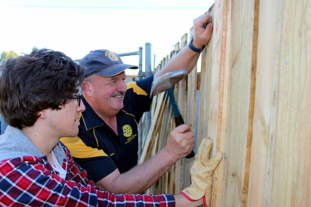 NAILED IT: Central Launceston Rotary Club's Alan Harris and Spanish Rotary Exchange student Inaki Sanchez help erect a new fence at New Horizons Club in Mowbray.