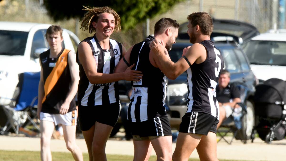SCHNEIDER WEB: Scottsdale's Tom McWatters and Joseph Robinson celebrate a goal with ex-AFL star Adam Schneider in the clash against Longford.