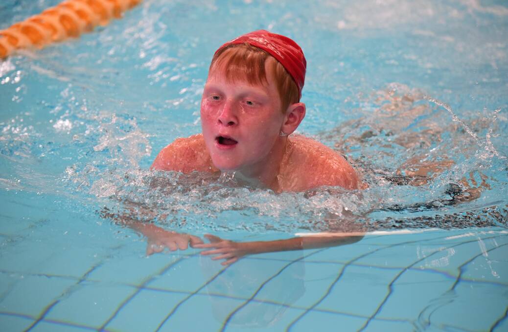 Grade 8 swimmer Jayden Hinds finishes his breaststroke race.