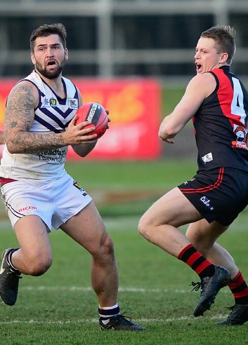 IN TRAFFIC: Burnie's Zane Murphy looks for an option as North Launceston's Mark Walsh moves in during their clash at Aurora Stadium. Picture: Phil Biggs