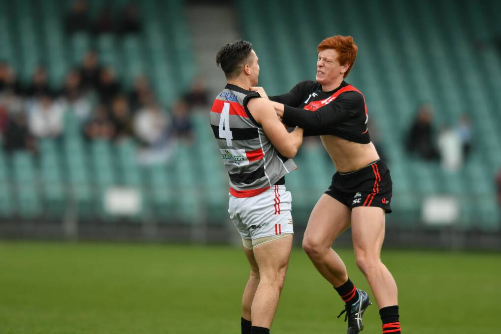 KEY MOMENT: Young gun Bomber Tom Donnelly defends himself against Lauderdale's Thor Boscott on the wing before the start of the grand final at UTAS Stadium.