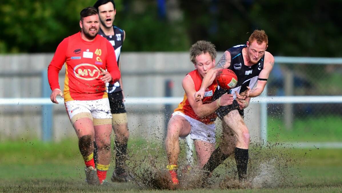 SLOPPY: Meander Valley's Ben Lynch tackles Perth midfielder Josh Streets in muddy conditions at Perth on Saturday. Picture: Phillip Biggs