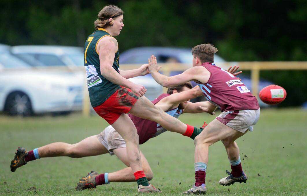 Swamped: Bridgenorth's James McIndoe gets a kick away despite smothering attempts by Hillwood duo Nathan Pearce and Brad Dikkenberg. Picture: Phillip Biggs.